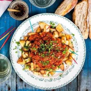 Oven-baked Patatas Bravas with sea bass