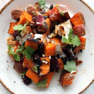 Roasted sweet potatoes, onions and nuts salad, topped with goat cheese