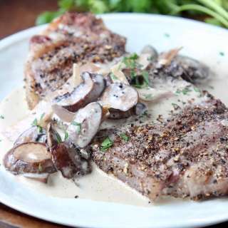 Grilled New York Strip Steak with Peppercorn Crust and Creamy Mushroom Sauce