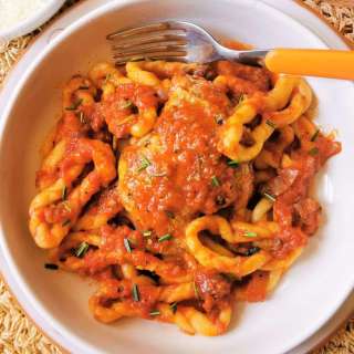 Homemade lorighittas with chicken ragu. A traditional recipe from Sardinia