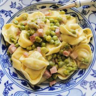 Creamy tortellini with ham and peas.