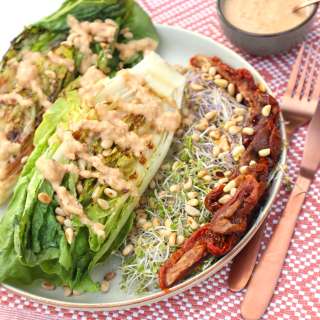 Grilled Romaine lettuce with pine nuts, dried tomatoes and vegan garlic cream sauce