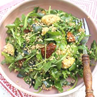 Couscous salad from millet with arugula, courgette, sundried tomatoes and pine nuts