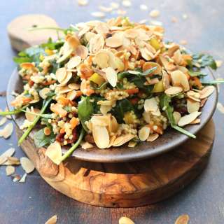 Arugula salad with millet, sundried tomatoes, yellow bell pepper and shaved almonds