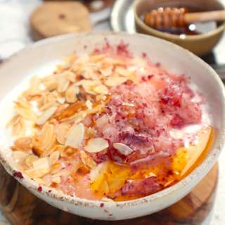 Shaved ice from frozen nectarine with yoghurt, roasted almonds and honey