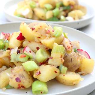Potato salad with spring onion, radishes and orange honey dressing