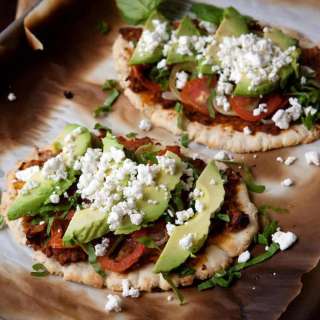 Huaraches Topped with Chorizo Refried Beans, Tomatoes, and Avocados