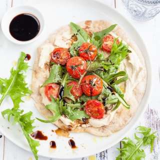 Flatbread pizza recipe with hummus, cherry tomato and dandelion greens