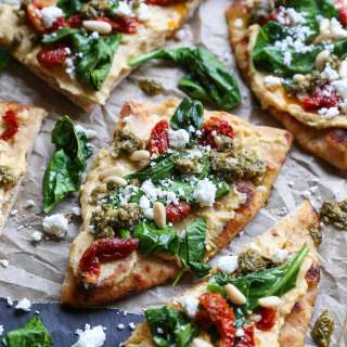 Hummus Flatbread with Sun-Dried Tomatoes, Spinach, and Pesto